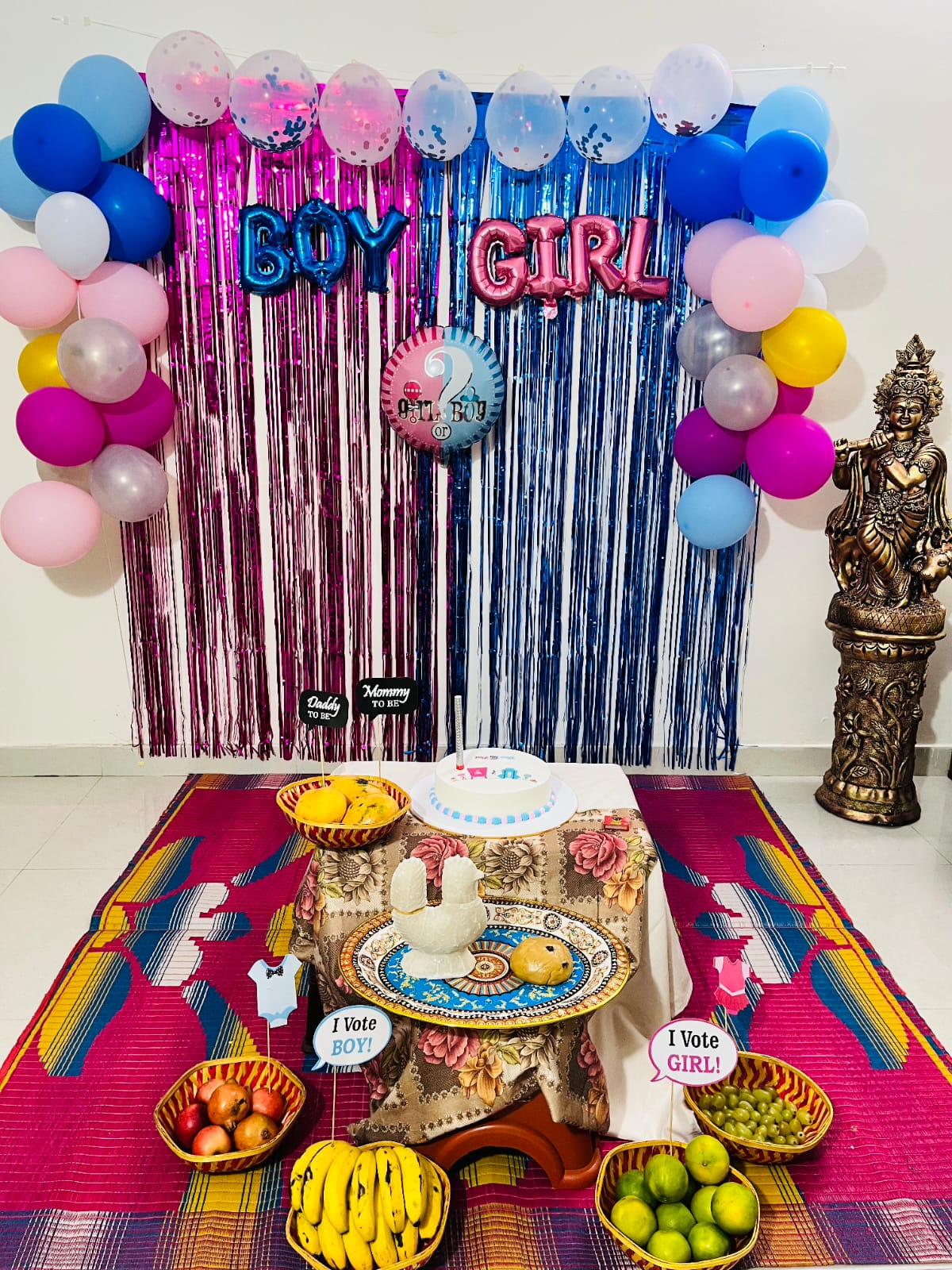 Gender reveal decoration with pink and blue balloons, foil curtain backdrop and BOY or GIRL letters by GK Signature